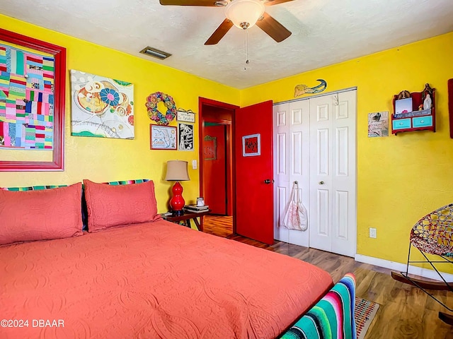 bedroom with hardwood / wood-style floors, ceiling fan, and a closet