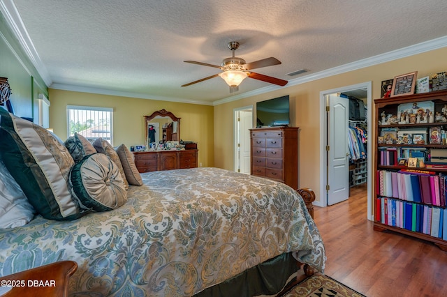 10 Cantilever Ct, Ormond Beach, FL 32174 - bedroom featuring wood finished floors, crown molding, a walk in closet, a textured ceiling, and a closet