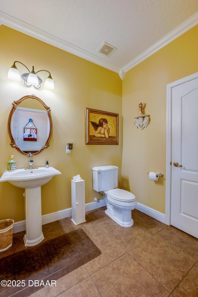 10 Cantilever Ct, Ormond Beach, FL 32174 - bathroom with ornamental molding, toilet, baseboards, tile patterned floors, and a textured ceiling