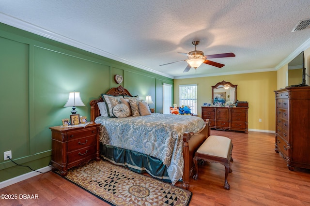 10 Cantilever Ct, Ormond Beach, FL 32174 - bedroom with ornamental molding, wood finished floors, a textured ceiling, baseboards, and ceiling fan