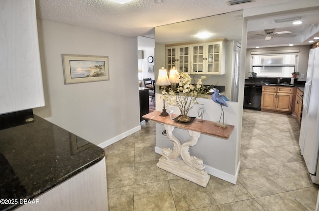 4435 S Atlantic Ave Unit 416, Ponce Inlet, FL 32127 - kitchen with dishwasher, brown cabinets, glass insert cabinets, light tile patterned flooring, and dark stone countertops