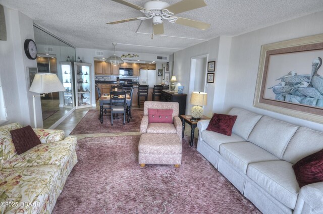 4435 S Atlantic Ave Unit 416, Ponce Inlet, FL 32127 - living room featuring a ceiling fan, a textured ceiling, and dark carpet