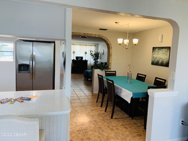 tiled dining area with a notable chandelier