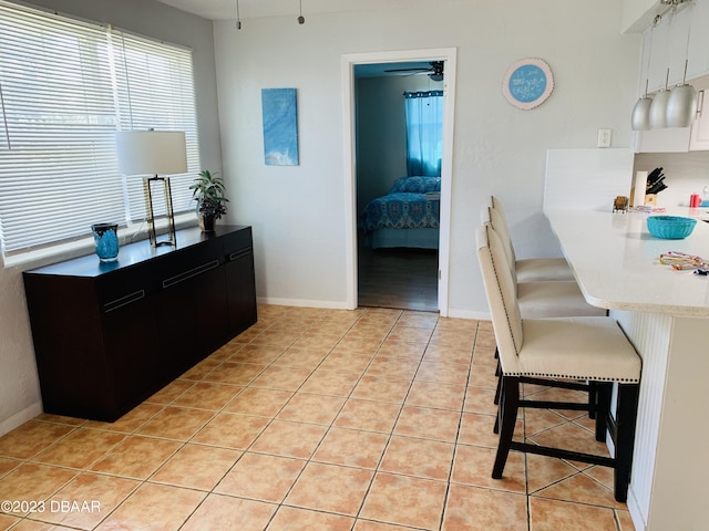 interior space featuring light tile patterned flooring and ceiling fan