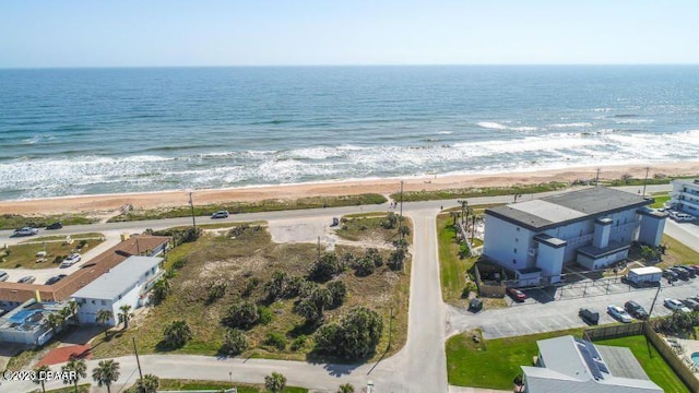 birds eye view of property featuring a water view and a beach view