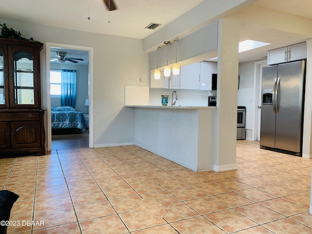 kitchen with pendant lighting, range, white cabinetry, stainless steel refrigerator with ice dispenser, and kitchen peninsula