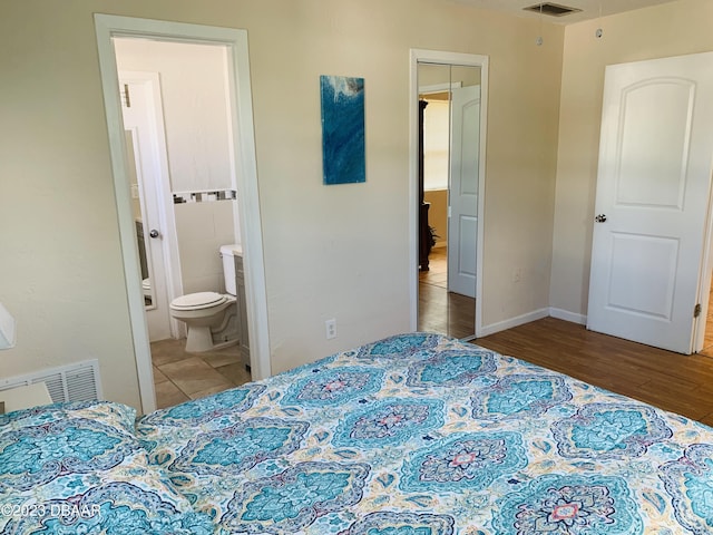 bedroom featuring hardwood / wood-style floors and ensuite bath