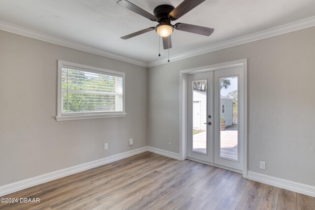 empty room featuring ornamental molding, french doors, light hardwood / wood-style floors, and ceiling fan