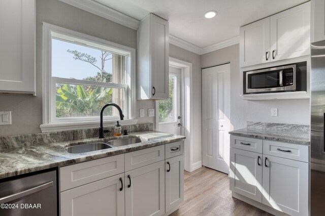 kitchen featuring light hardwood / wood-style floors, white cabinets, sink, light stone countertops, and appliances with stainless steel finishes