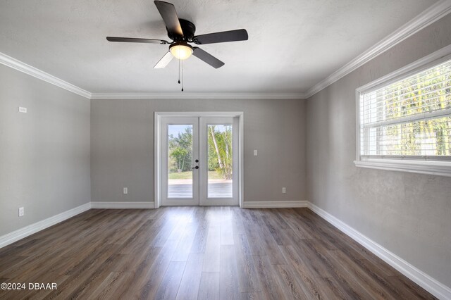 empty room with dark hardwood / wood-style flooring, ornamental molding, french doors, and ceiling fan