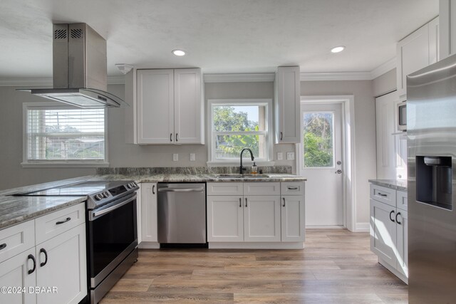 kitchen featuring range hood, white cabinetry, appliances with stainless steel finishes, sink, and light hardwood / wood-style floors