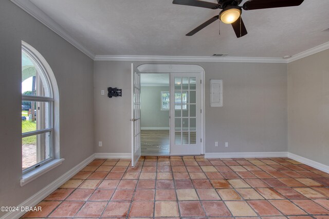 tiled empty room featuring ceiling fan, french doors, and ornamental molding