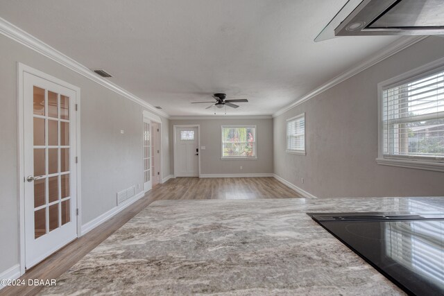 foyer entrance featuring light wood-type flooring, ceiling fan, and crown molding