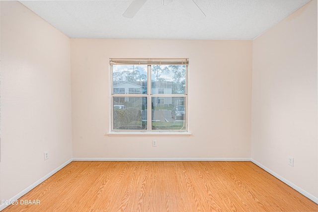 empty room with baseboards, a ceiling fan, and wood finished floors