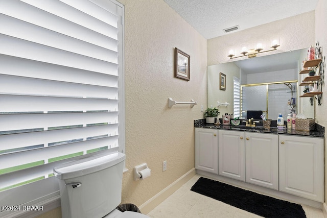 bathroom featuring a textured ceiling, vanity, toilet, and an enclosed shower