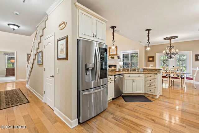 kitchen featuring kitchen peninsula, light wood-type flooring, stainless steel appliances, and a healthy amount of sunlight