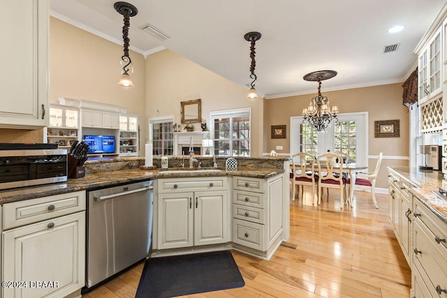 kitchen featuring dark stone countertops, dishwasher, decorative light fixtures, and light hardwood / wood-style flooring