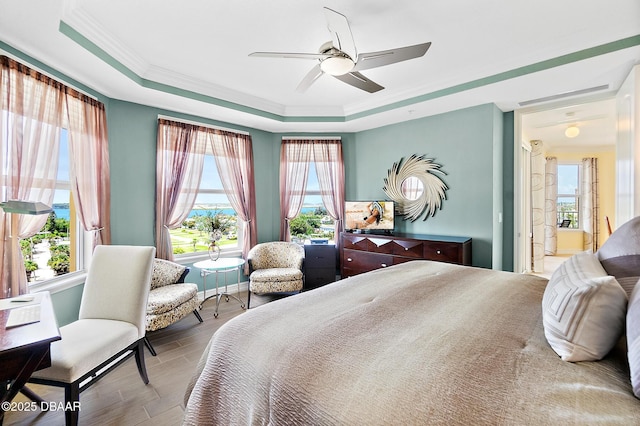 3343 S Atlantic Ave Unit 601, Daytona Beach Shores, FL 32118 - bedroom featuring a tray ceiling, crown molding, wood finished floors, and a ceiling fan