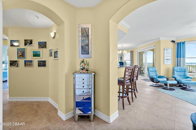 3343 S Atlantic Ave Unit 601, Daytona Beach Shores, FL 32118 - hall with arched walkways, a chandelier, crown molding, and tile patterned flooring