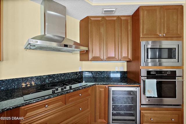 3343 S Atlantic Ave Unit 601, Daytona Beach Shores, FL 32118 - kitchen featuring beverage cooler, wall chimney exhaust hood, appliances with stainless steel finishes, brown cabinetry, and a textured ceiling