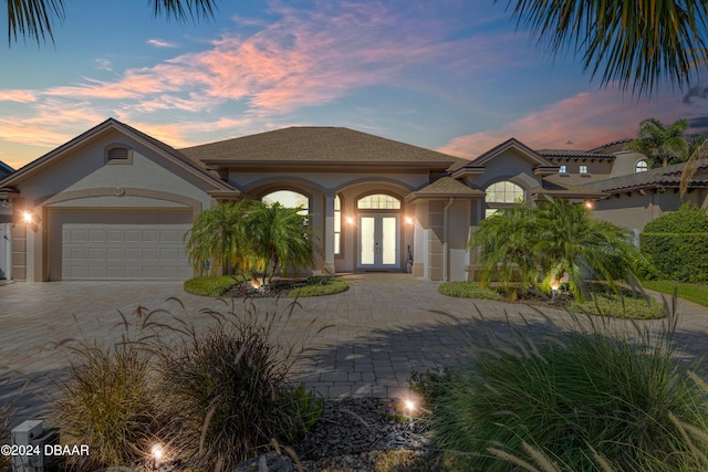 mediterranean / spanish house featuring a garage and french doors