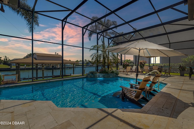 pool at dusk with a patio area, a water view, and a lanai