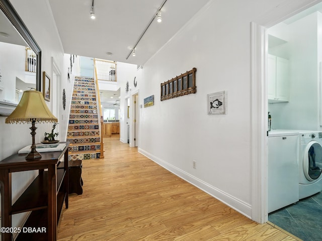206 S Riverside Dr, Edgewater, FL 32132 - corridor featuring washing machine and dryer, rail lighting, stairs, and light wood-style floors