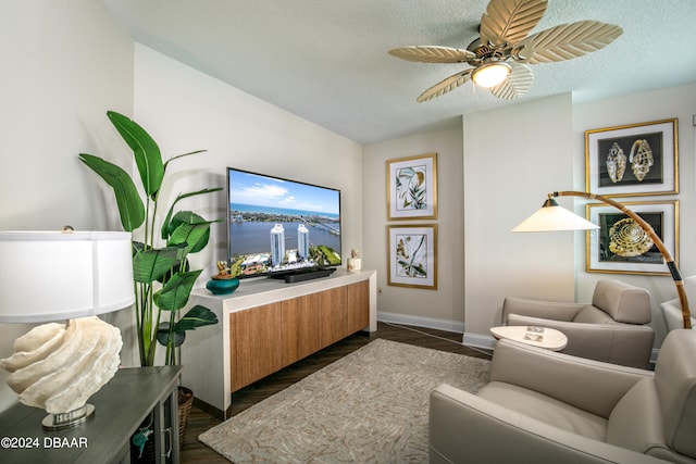 living area featuring dark hardwood / wood-style floors, ceiling fan, and a textured ceiling