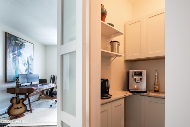 interior space with light stone counters and white cabinets