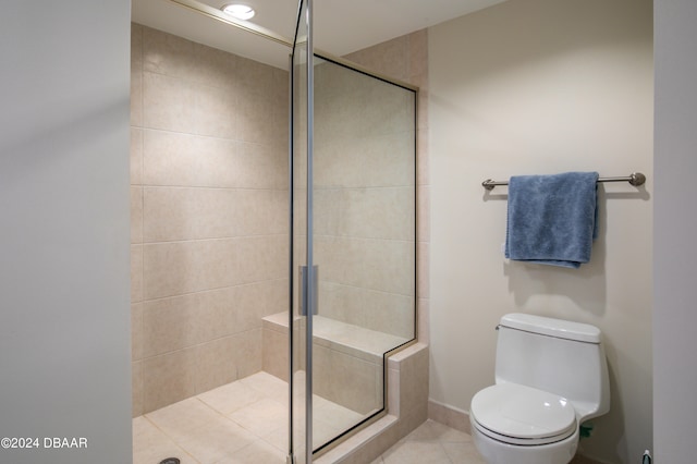 bathroom with a shower with door, tile patterned flooring, and toilet