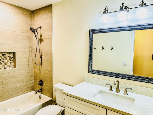 full bathroom featuring tiled shower / bath, vanity, and toilet