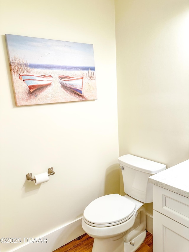 bathroom featuring vanity, hardwood / wood-style flooring, and toilet