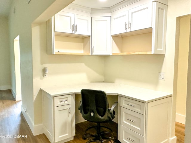 home office with hardwood / wood-style flooring and built in desk