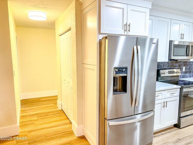 unfurnished bedroom featuring a closet, a walk in closet, light hardwood / wood-style floors, and ensuite bath