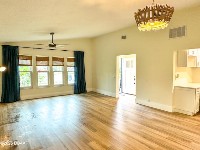 unfurnished living room with ceiling fan, vaulted ceiling, and light hardwood / wood-style flooring