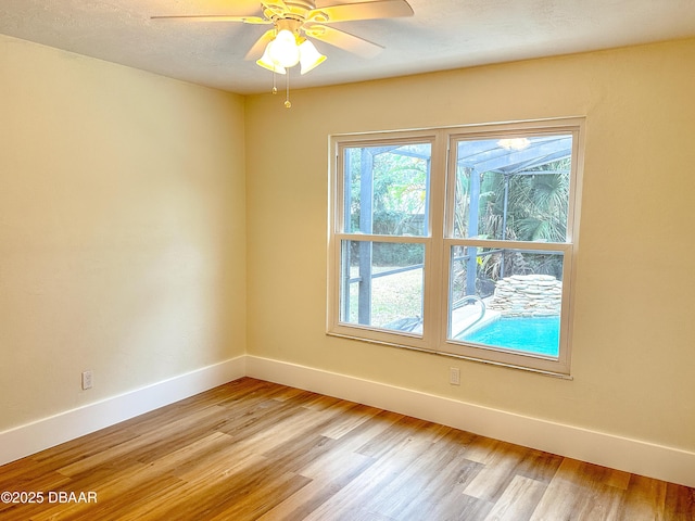 unfurnished room with ceiling fan, light hardwood / wood-style flooring, and a textured ceiling