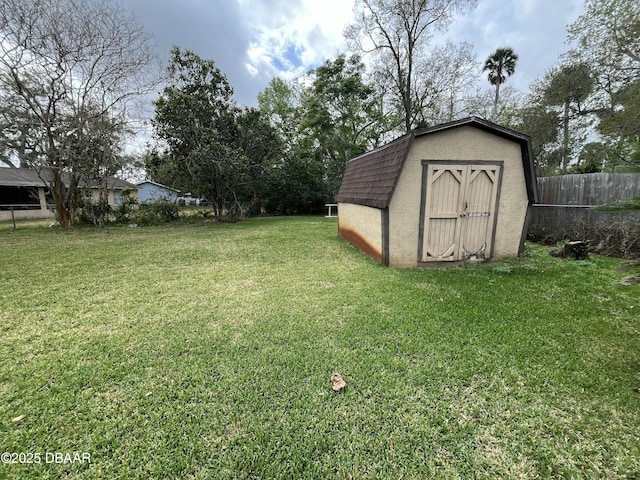 view of yard with an outdoor structure, a storage shed, and fence