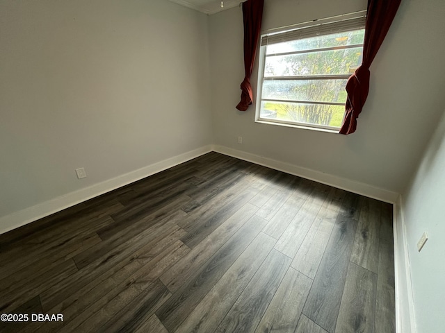 empty room with dark wood-style floors and baseboards