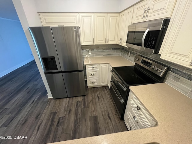 kitchen with dark wood-type flooring, white cabinetry, light countertops, appliances with stainless steel finishes, and backsplash