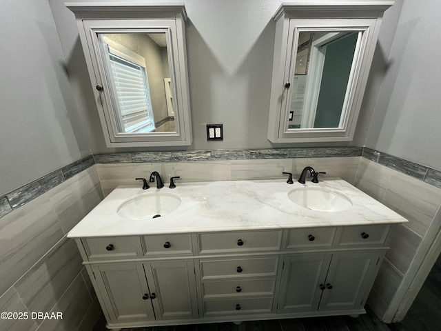 full bathroom with double vanity, tile walls, and a sink