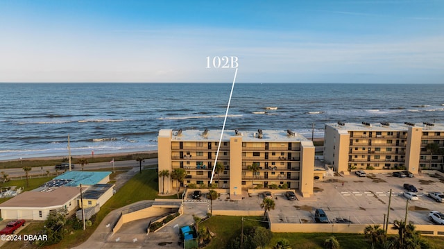 drone / aerial view featuring a water view and a beach view