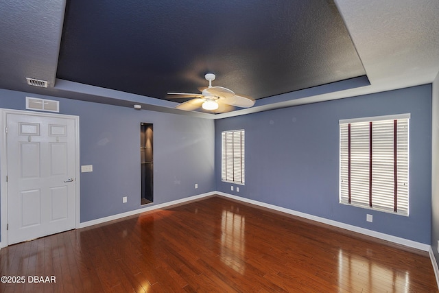6065 Spruce Point Cir, Port Orange, FL 32128 - spare room with a tray ceiling, a ceiling fan, wood finished floors, and a textured ceiling