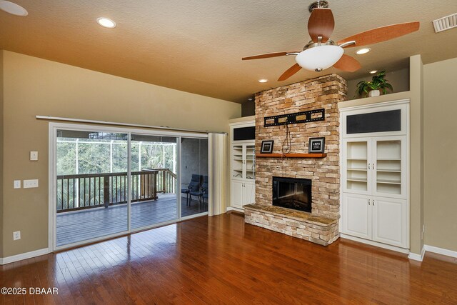 6065 Spruce Point Cir, Port Orange, FL 32128 - unfurnished living room with hardwood / wood-style floors, a stone fireplace, a textured ceiling, a ceiling fan, and recessed lighting