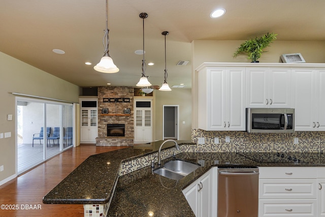 6065 Spruce Point Cir, Port Orange, FL 32128 - kitchen with stainless steel appliances, a fireplace, open floor plan, tasteful backsplash, and wood finished floors