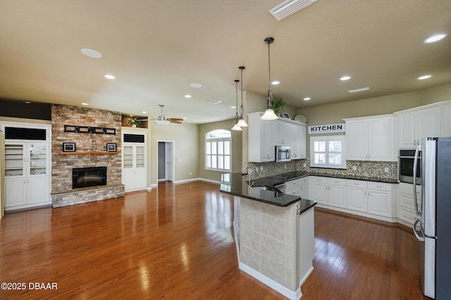 6065 Spruce Point Cir, Port Orange, FL 32128 - kitchen featuring appliances with stainless steel finishes, a peninsula, white cabinetry, dark countertops, and recessed lighting
