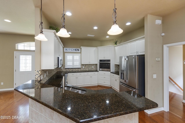 6065 Spruce Point Cir, Port Orange, FL 32128 - kitchen featuring stainless steel appliances, a peninsula, decorative backsplash, dark wood-style floors, and recessed lighting