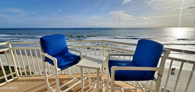 balcony featuring a beach view and a water view