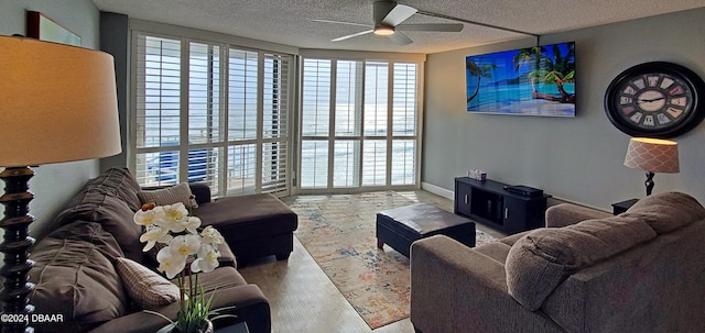 living room with hardwood / wood-style floors, ceiling fan, and a textured ceiling