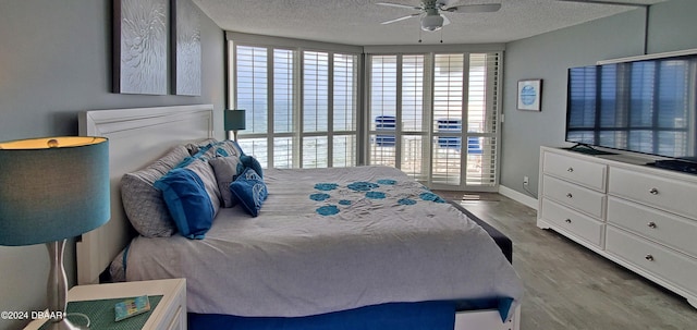 bedroom featuring hardwood / wood-style floors, a textured ceiling, and ceiling fan