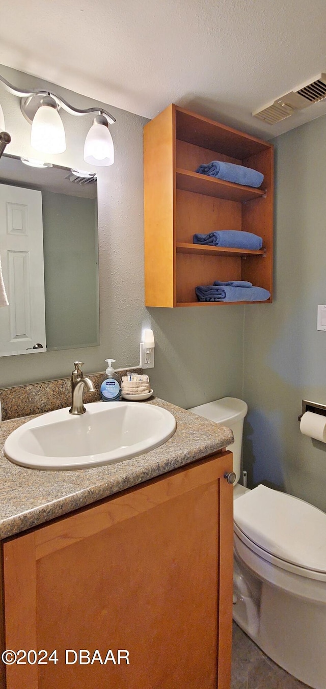 bathroom with tile patterned floors, vanity, and toilet